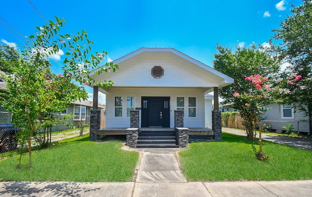 view of front facade with a front yard and covered porch