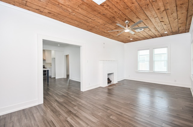 unfurnished living room with ceiling fan, a brick fireplace, dark wood-type flooring, and crown molding