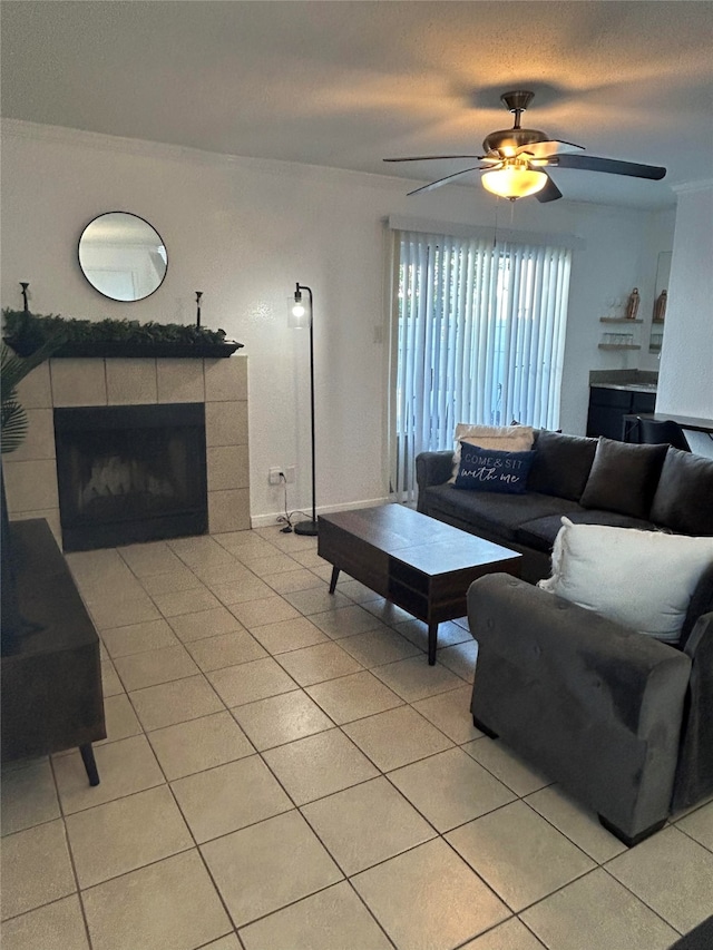 tiled living room with ceiling fan and a fireplace