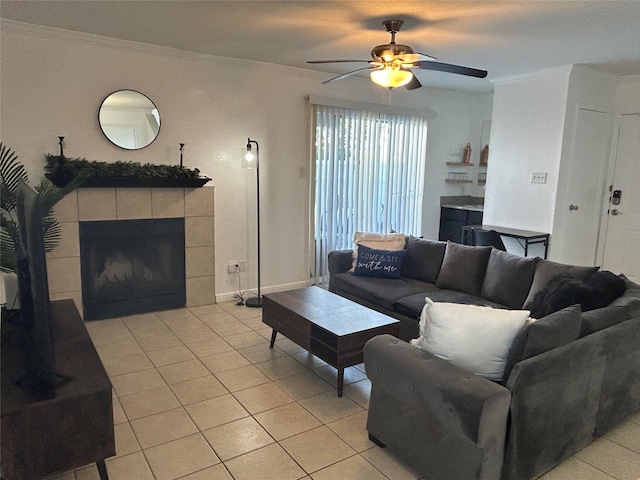 tiled living room featuring ceiling fan, a tiled fireplace, and crown molding