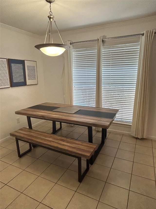 dining area with crown molding and light tile patterned floors