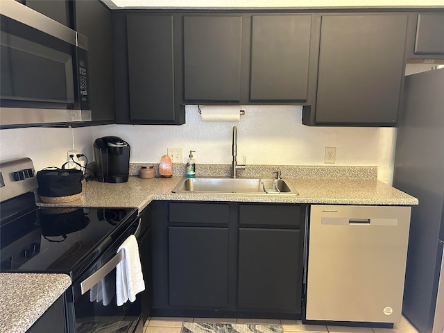 kitchen with stainless steel appliances, light tile patterned floors, and sink