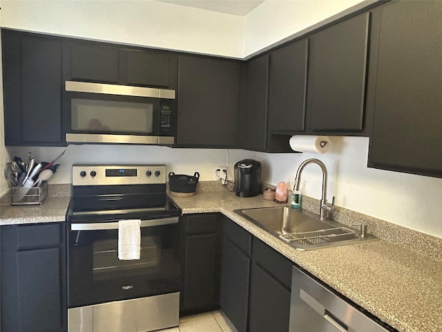 kitchen with light tile patterned flooring, stainless steel appliances, and sink