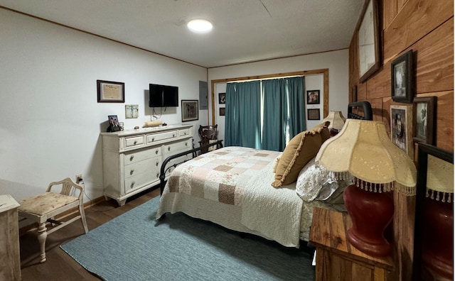 bedroom featuring wood walls and a fireplace