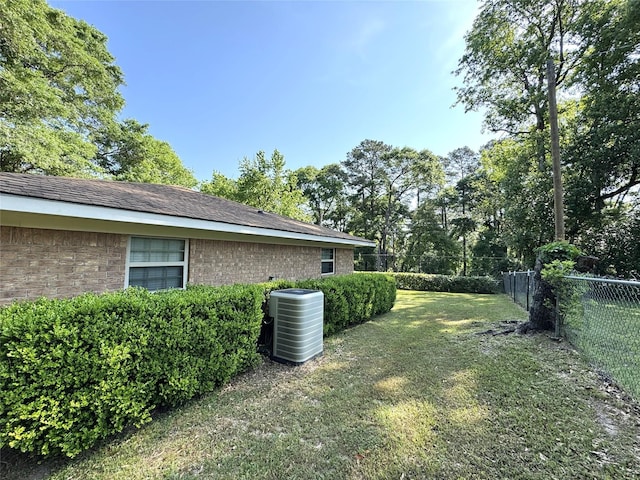 view of yard featuring central air condition unit and fence