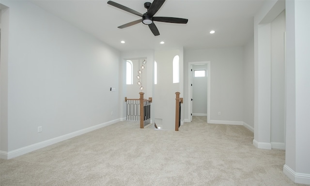 carpeted spare room featuring ceiling fan