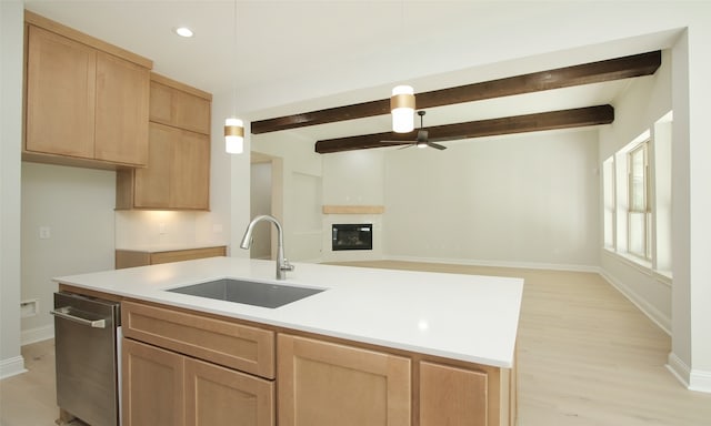 kitchen featuring light hardwood / wood-style floors, beamed ceiling, a kitchen island with sink, sink, and ceiling fan