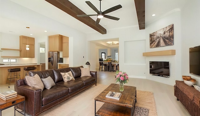 living room featuring a wealth of natural light, beam ceiling, ceiling fan, and light hardwood / wood-style floors