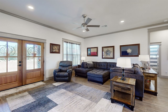 living room featuring ceiling fan, ornamental molding, french doors, and light hardwood / wood-style floors