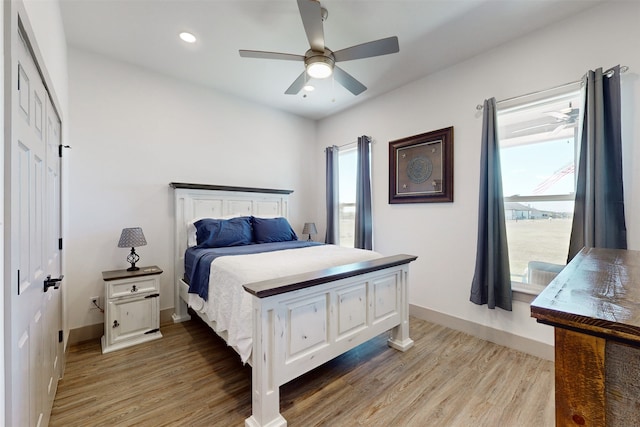 bedroom with hardwood / wood-style floors, ceiling fan, and a closet