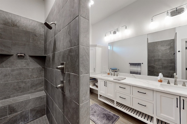 bathroom with a tile shower, hardwood / wood-style floors, and vanity