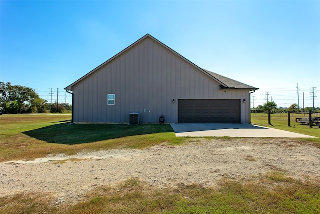 view of property exterior with a lawn, cooling unit, and a garage