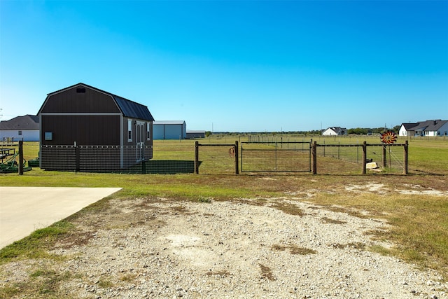 view of yard featuring an outdoor structure and a rural view