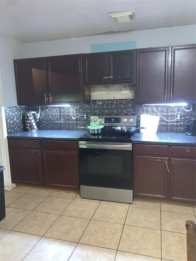 kitchen featuring decorative backsplash, light tile patterned floors, and stainless steel electric range oven