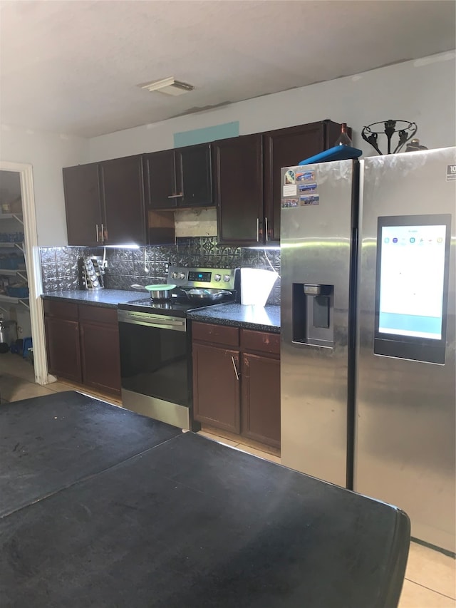 kitchen featuring dark brown cabinetry, appliances with stainless steel finishes, light tile patterned floors, and decorative backsplash