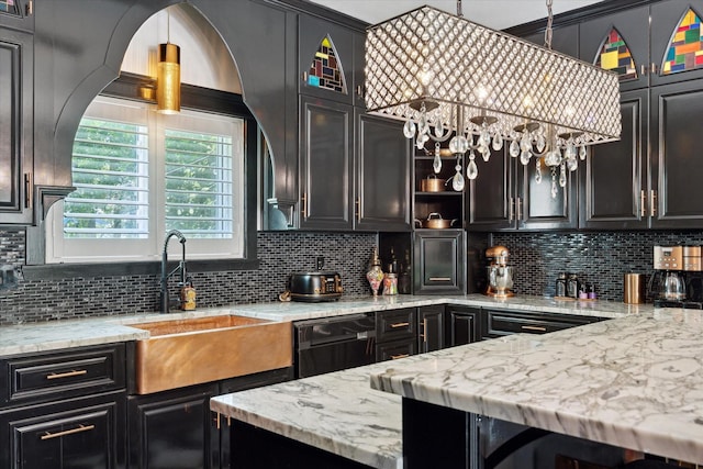 kitchen with decorative backsplash, light stone counters, and sink