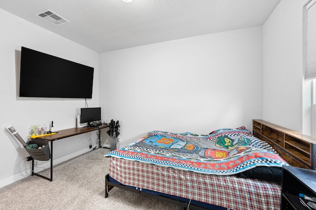 bedroom with a textured ceiling and light colored carpet