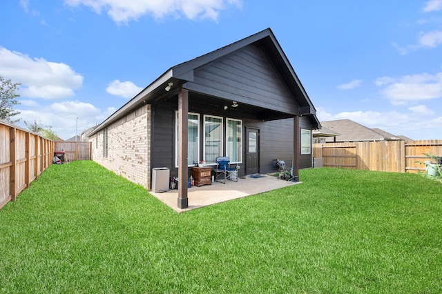 rear view of property featuring a lawn and a patio