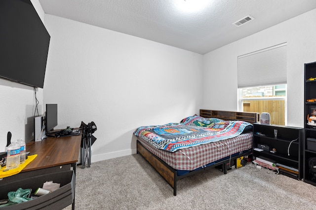 bedroom with carpet floors and a textured ceiling