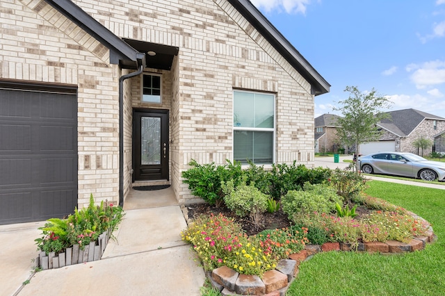 entrance to property with a lawn and a garage