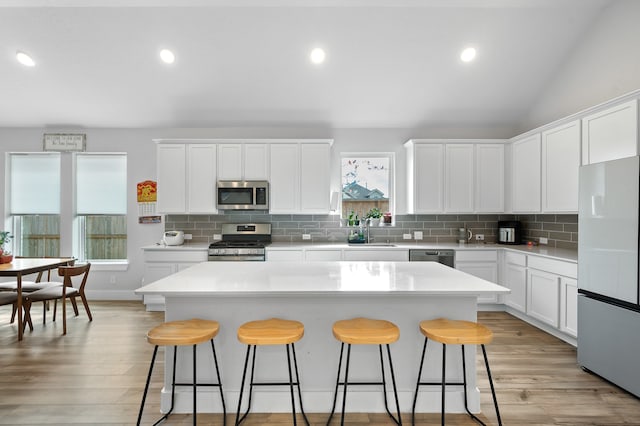 kitchen featuring white cabinets, stainless steel appliances, and a center island