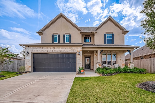 view of front of property featuring a front lawn, covered porch, and a garage