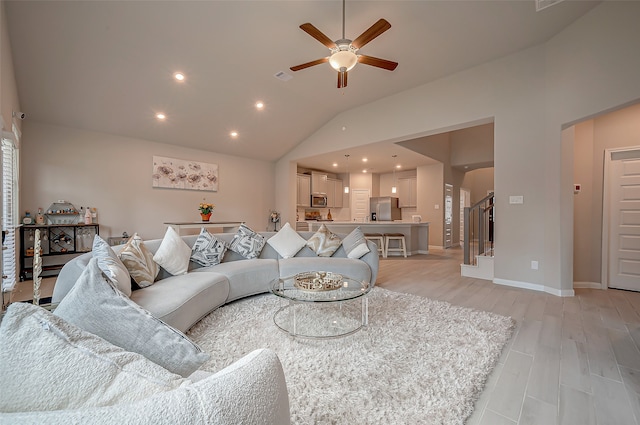 living room featuring lofted ceiling, ceiling fan, and light hardwood / wood-style floors