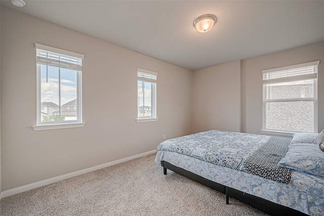 carpeted bedroom featuring multiple windows