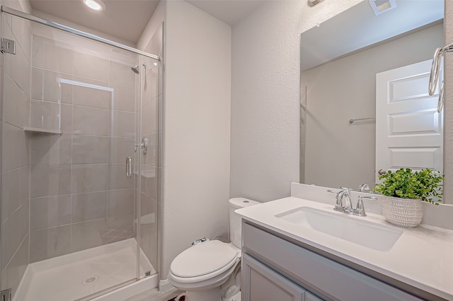 bathroom with vanity, toilet, and an enclosed shower