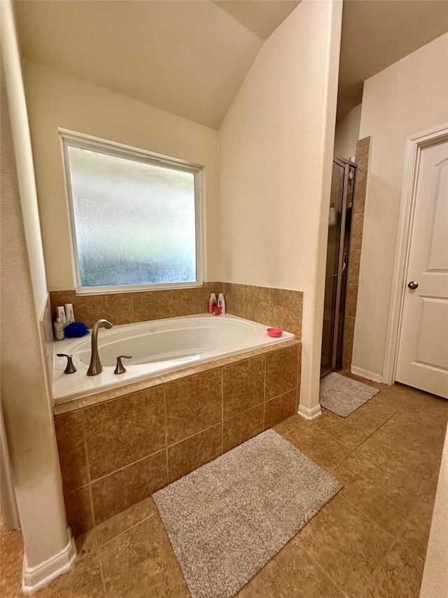 bathroom featuring independent shower and bath, lofted ceiling, and tile patterned flooring