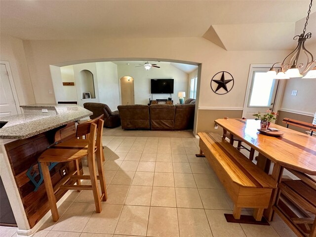 dining space featuring light tile patterned floors, vaulted ceiling, and ceiling fan