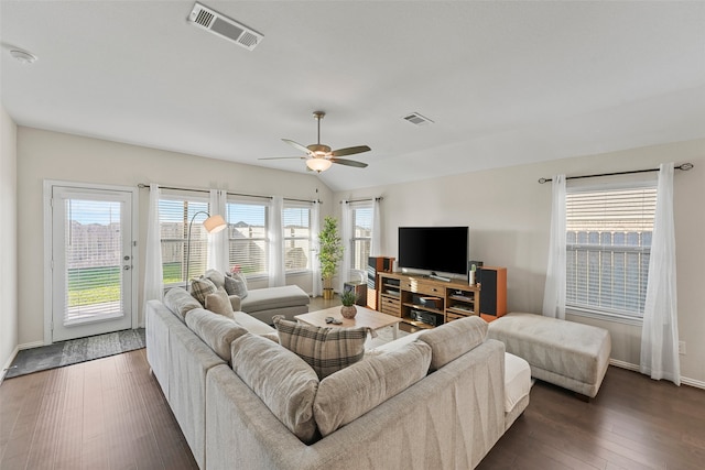 living room with ceiling fan, vaulted ceiling, and dark hardwood / wood-style flooring