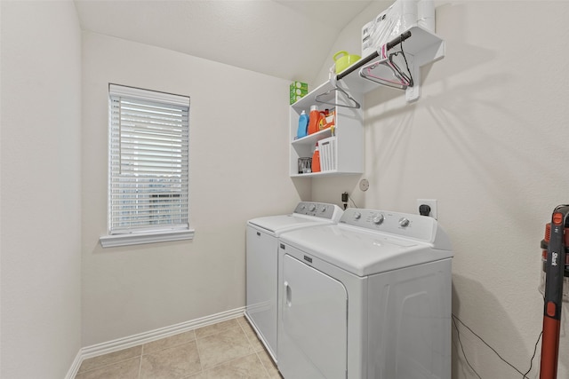 laundry area with washing machine and clothes dryer and light tile patterned floors