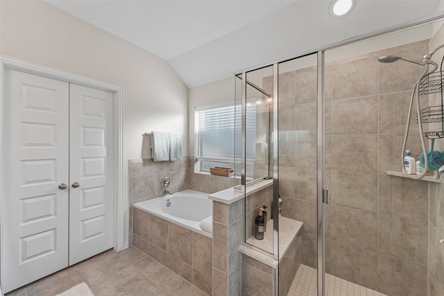 bathroom with shower with separate bathtub, vaulted ceiling, and tile patterned floors