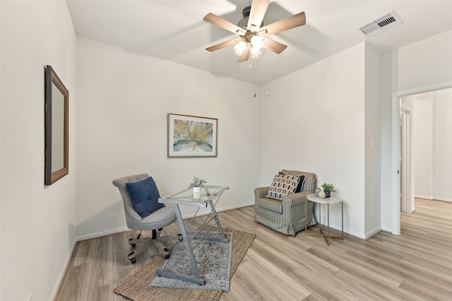 living area with ceiling fan and light hardwood / wood-style floors