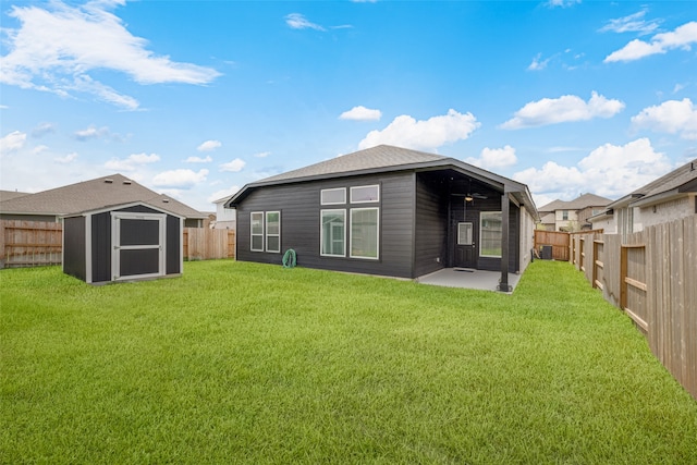 rear view of property with a storage shed, a yard, and a patio