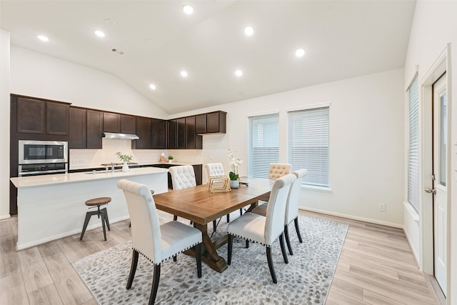 dining space with light hardwood / wood-style floors and lofted ceiling