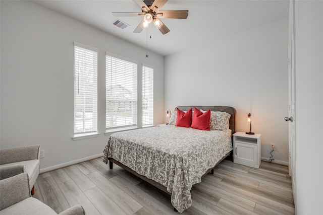 bedroom with light wood-type flooring, multiple windows, and ceiling fan