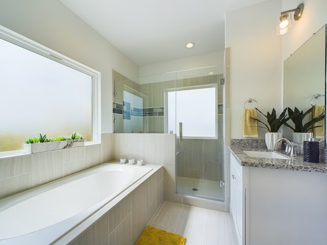 bathroom with shower with separate bathtub, tile patterned floors, and vanity