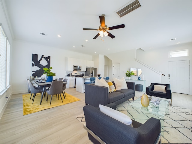 living room with light wood-type flooring and ceiling fan