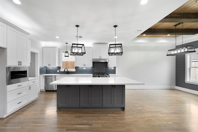 kitchen featuring stainless steel appliances, a kitchen island, and white cabinetry