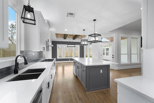 kitchen featuring white cabinets, a kitchen island, and a healthy amount of sunlight