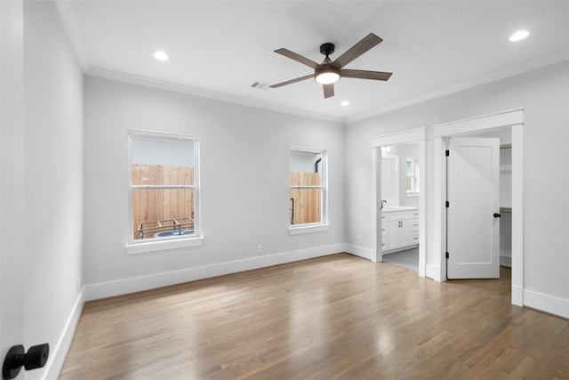 unfurnished bedroom with hardwood / wood-style flooring, ceiling fan, connected bathroom, and multiple windows