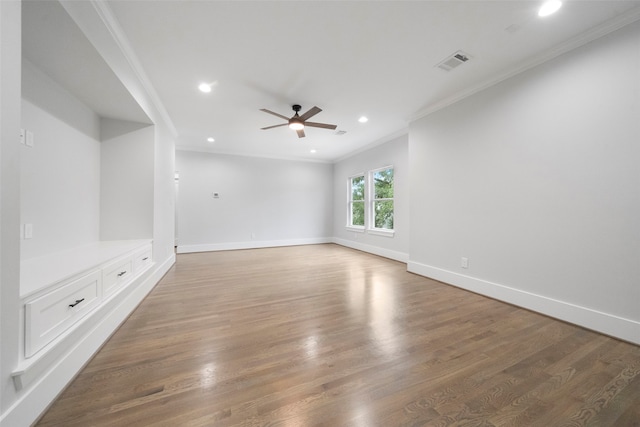 unfurnished living room with hardwood / wood-style flooring, ceiling fan, and crown molding