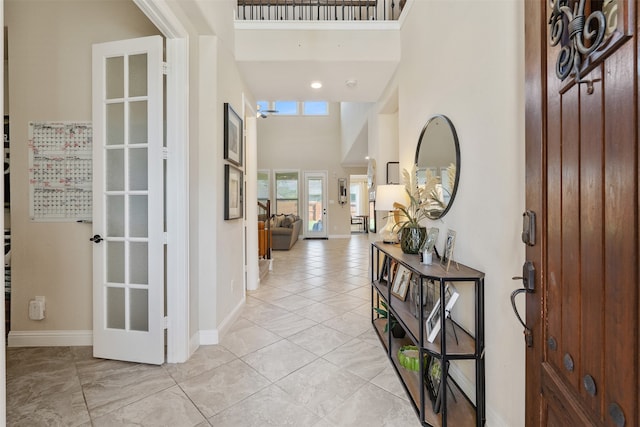 tiled entrance foyer with a towering ceiling