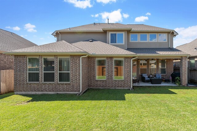 back of house featuring a lawn, a patio, and an outdoor hangout area