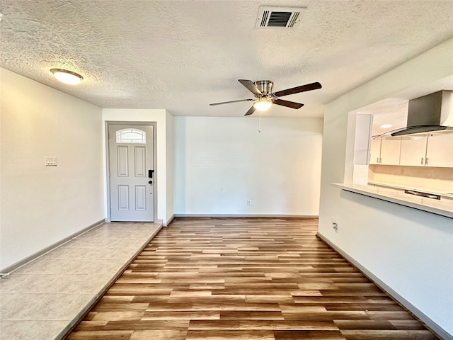 entrance foyer featuring a textured ceiling, light hardwood / wood-style floors, and ceiling fan