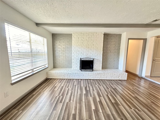 unfurnished living room with a textured ceiling, a fireplace, and hardwood / wood-style floors