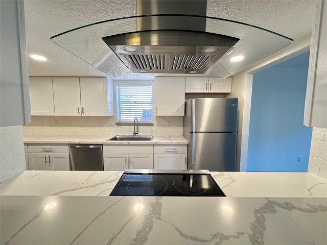 kitchen with appliances with stainless steel finishes, white cabinetry, range hood, and tasteful backsplash