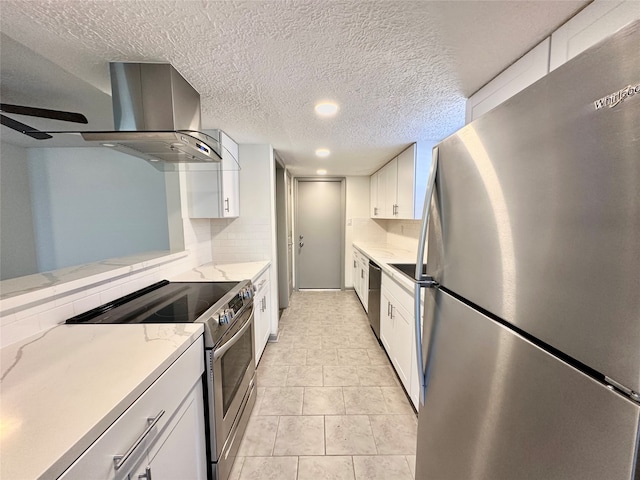 kitchen featuring light stone counters, white cabinetry, decorative backsplash, stainless steel appliances, and wall chimney exhaust hood